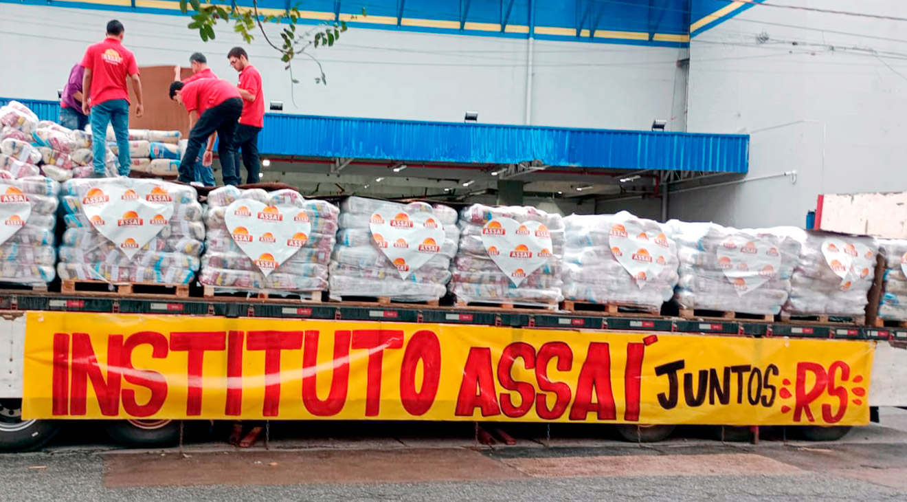 Colaboradores da loja Assaí Curitiba Kennedy ajudando a carregar o caminhão com alimentos que serão doados às vítimas das enchentes no Rio Grande do Sul